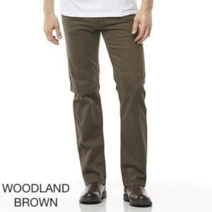 A person is wearing Riders Straight Moleskin Stretch trousers in woodland brown, standing upright against a white background. The stylish casual pants are paired with dark brown shoes and a white top. The text "WOODLAND BROWN" is displayed in the bottom left corner.