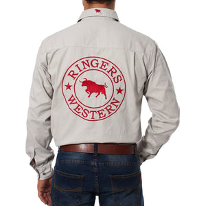 A person is wearing the Ringers Western Hawkeye Embroidered Shirt, a beige long-sleeve work shirt with "Ringers Western" and a red bull logo on the back. Made of 100% cotton with UPF50+ protection, it has front chest pockets and buttons. They are also wearing blue jeans.
