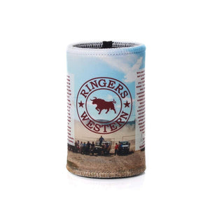 The Ringers Western Signature Bull Stubby is a cylindrical drink holder featuring a prominently displayed "Ringers Western" logo with a bull icon and red text. The background showcases an outdoor scene with people and vehicles, ensuring your drinks stay cool while exuding style.