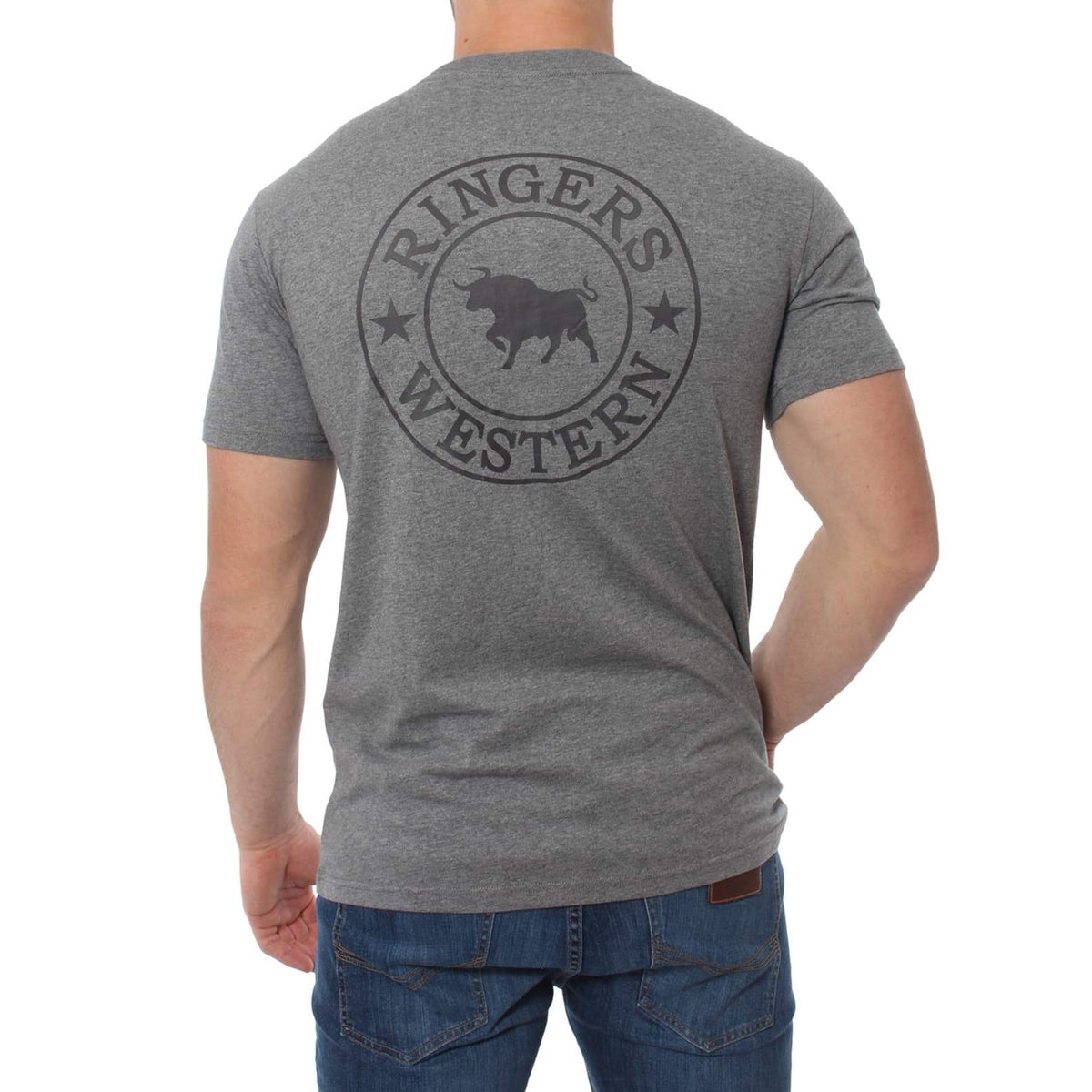 A person wearing a Ringers Western Signature Bull Classic T-Shirt with the words "RINGERS WESTERN" and a bull logo printed on the back stands with their back facing the camera, paired comfortably with blue jeans.