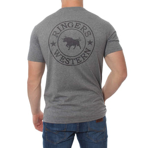 A person wearing a Ringers Western Signature Bull Classic T-Shirt with the words "RINGERS WESTERN" and a bull logo printed on the back stands with their back facing the camera, paired comfortably with blue jeans.