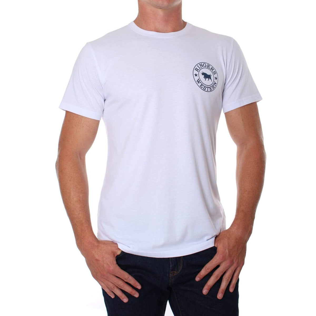 A person wearing a comfortable Ringers Western Signature Bull Classic T-Shirt, which is a plain white crew neck with a small circular graphic featuring a logo with text and an image of a bull on the left chest area, paired with dark jeans. The person has their hands resting on their hips against a plain white background.