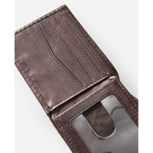 A Rip Curl Perforation RFID Slim Wallet in brown leather is open, showing off its card slots and transparent ID holder. Set against a plain white background, the wallet's texture showcases its craftsmanship, merging style with function.