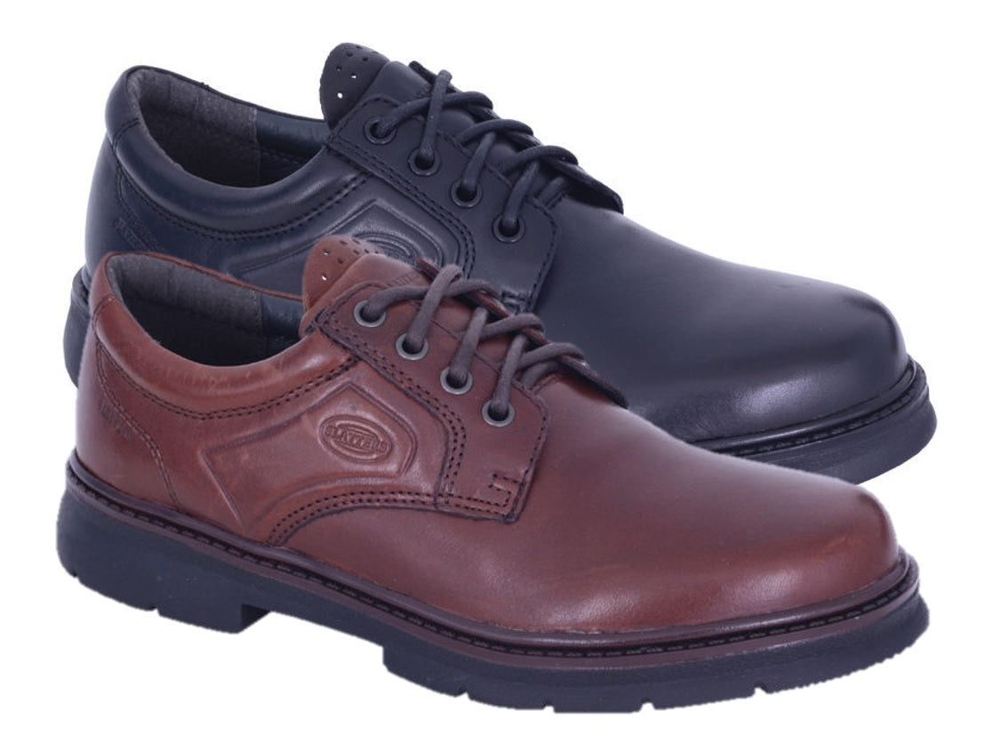 A pair of Slatters Senator men's dress shoes. In the foreground is a dark brown leather upper shoe with a lace-up design and a logo imprint on the side. Behind it is a black leather shoe with a similar design and lace-up closure. Both stylish shoes have thick, black rubber soles.