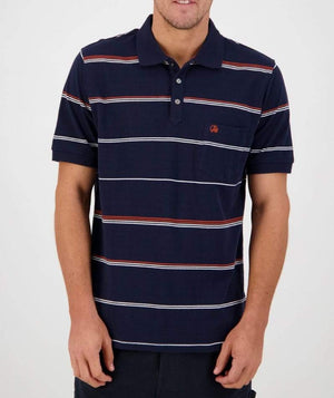 A person wearing the Swanndri Concord Stripe Polo, a navy blue casual shirt adorned with white and red horizontal stripes and featuring the Swanndri logo. The shirt has short sleeves, a small chest pocket, and a buttoned collar. They are standing against a plain white background, with their head not fully visible in the frame.