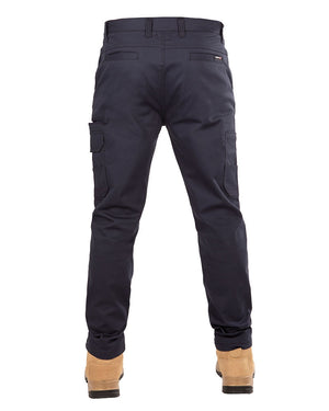 Rear view of a person wearing UNIT Demolition Stretch Cargo Pant in navy blue with UPF 50+ protection and light brown work boots. The durable work pant features multiple pockets, including cargo-style flap pockets on the sides of the thighs. The person's upper body is not visible.