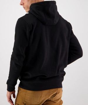 The image depicts someone wearing the Swanndri Original Fleece Hoody paired with brown pants from behind. The hood partially covers their head, and their left hand rests on their hip. The background is light-colored and plain.