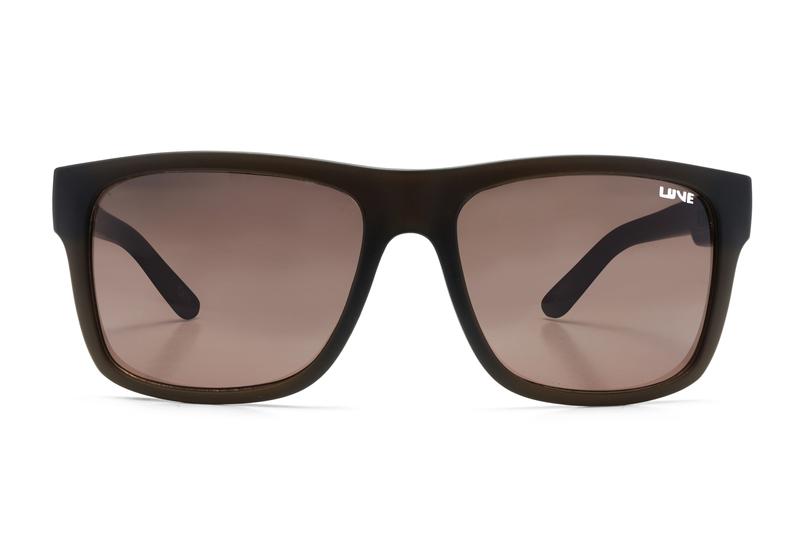 The Liive Sync Sunglasses feature a rectangular design with dark brown frames and slightly tinted, optically correct lenses. A small white "UNE" logo is positioned on the top right corner of the right lens. Crafted from lightweight polycarbonate, these sunglasses boast a simple and modern style, providing UV protection that makes them perfect for casual wear.