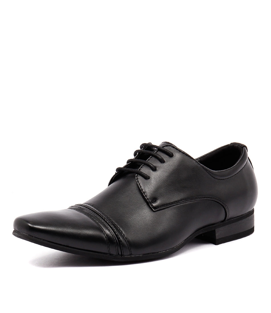 The UNcut Bartell Shoe is a black formal men's dress shoe with a polished leather finish and lace-up closure. This elegant shoe features a pointed toe, detailed stitching on the toe cap and sides, a low heel, and a slightly angled sole. It is available in UK sizing.