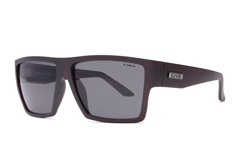 Rectangular, matte black Liive Volt Sunglasses featuring dark-tinted lenses. The frames are thick yet lightweight, made from durable polycarbonate and embellished with a metal "Live" logo on the arms near the hinges. These sunglasses boast a simple and modern design ideal for casual wear, providing reliable UV protection.