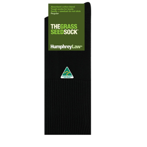 A pair of black socks, identified as the "Humphrey Law Grass Seed Sock - Short," is displayed against a white backdrop. These Australian-made socks feature packaging that reveals they are crafted from an absorbent cotton blend designed to prevent grass seed and sawdust from adhering.