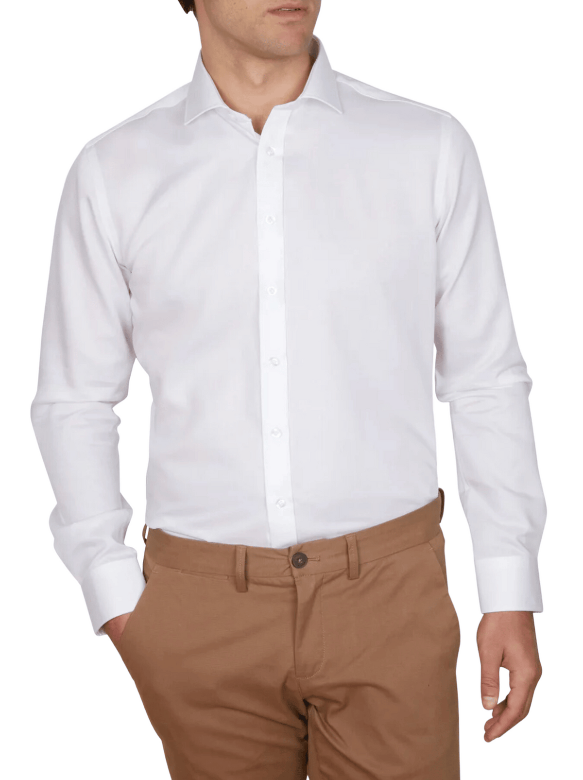 A person wears an Abelard Non Iron Cotton Twill Slim Fit Shirt in crisp white with brown pants, hand in pocket. The plain white background highlights the outfit’s modern simplicity.