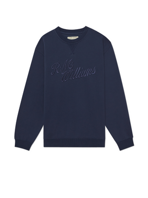 The RM Williams R.M.W Script Crew Neck is a navy blue jumper with "R.M. Williams" embroidered on the chest, crafted from a cozy cotton blend for comfort and featuring soft fabric along with ribbed cuffs and hem.