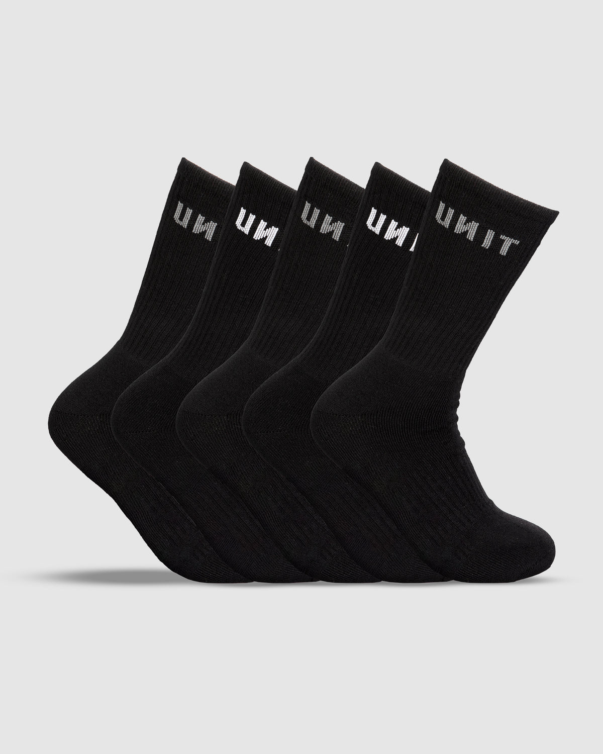 Five UNIT Respond Bamboo 5 Pack Socks line up against a white background. Each black crew sock displays "UNIT" in white near the top, providing an anti-bacterial benefit for lasting freshness.