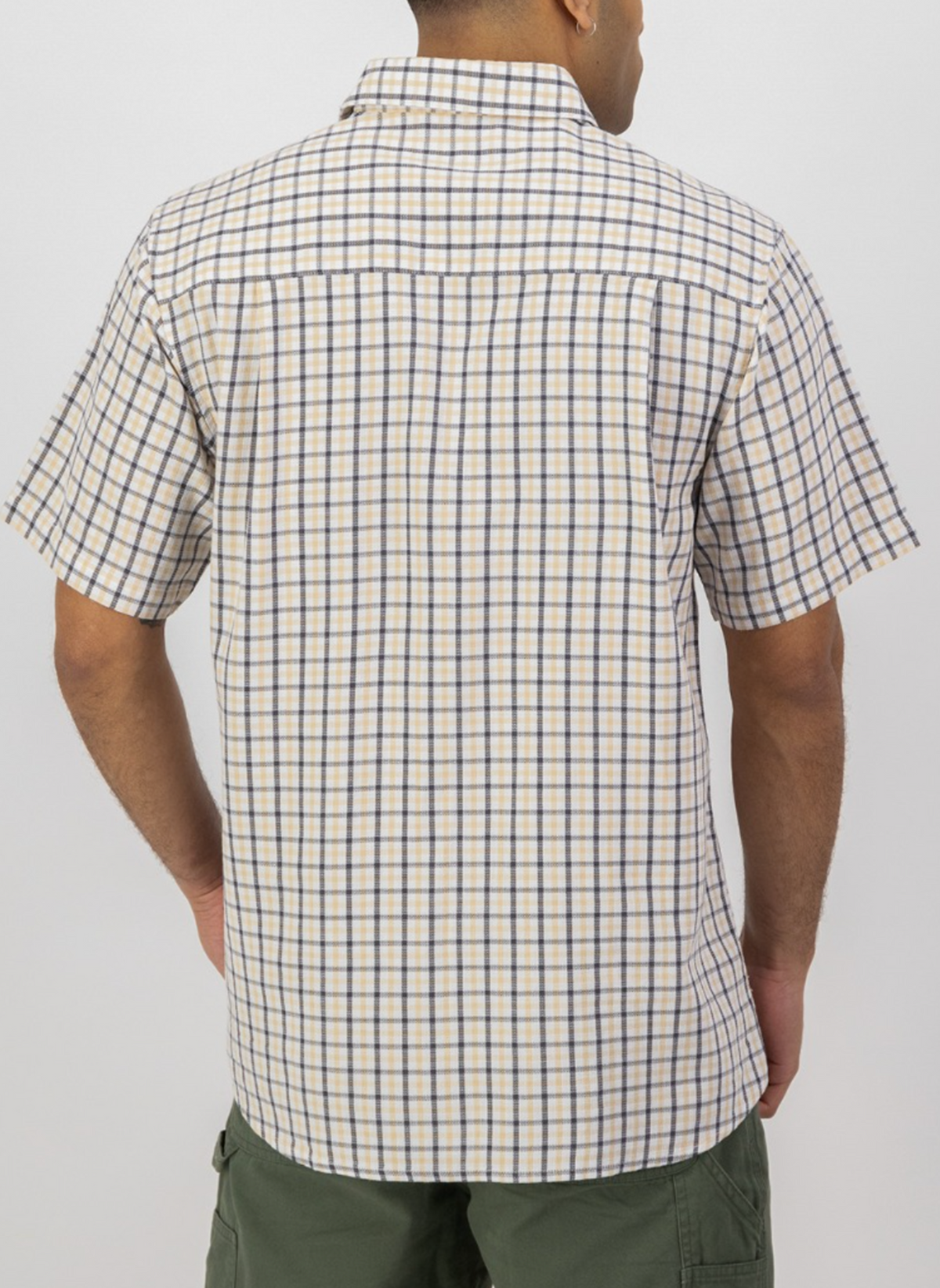 A man wearing a Swanndri Russell Shirt in beige and blue plaid with green shorts is shown from the back, standing against a plain light background.