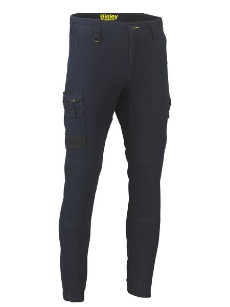 The Bisley Flex & Move Stretch Denim Cargo Cuffed Pant features multiple cargo pockets, a fitted design, reinforced knees, ankle zippers, and “Bisley” branding on the waistband for practical and stylish storage.