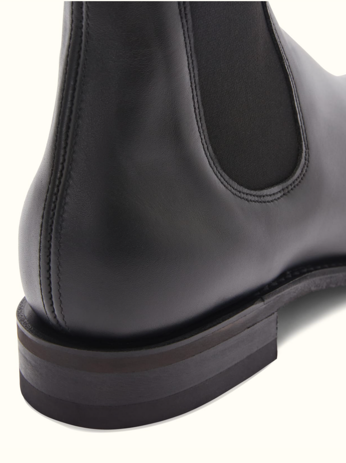 Close-up image of the back of an RM Williams Comfort Craftsman Boot in black leather, focusing on the smooth leather surface and stitching details. The image highlights the heel, durable rubber sole, and elastic side panel characteristic of these boots.
