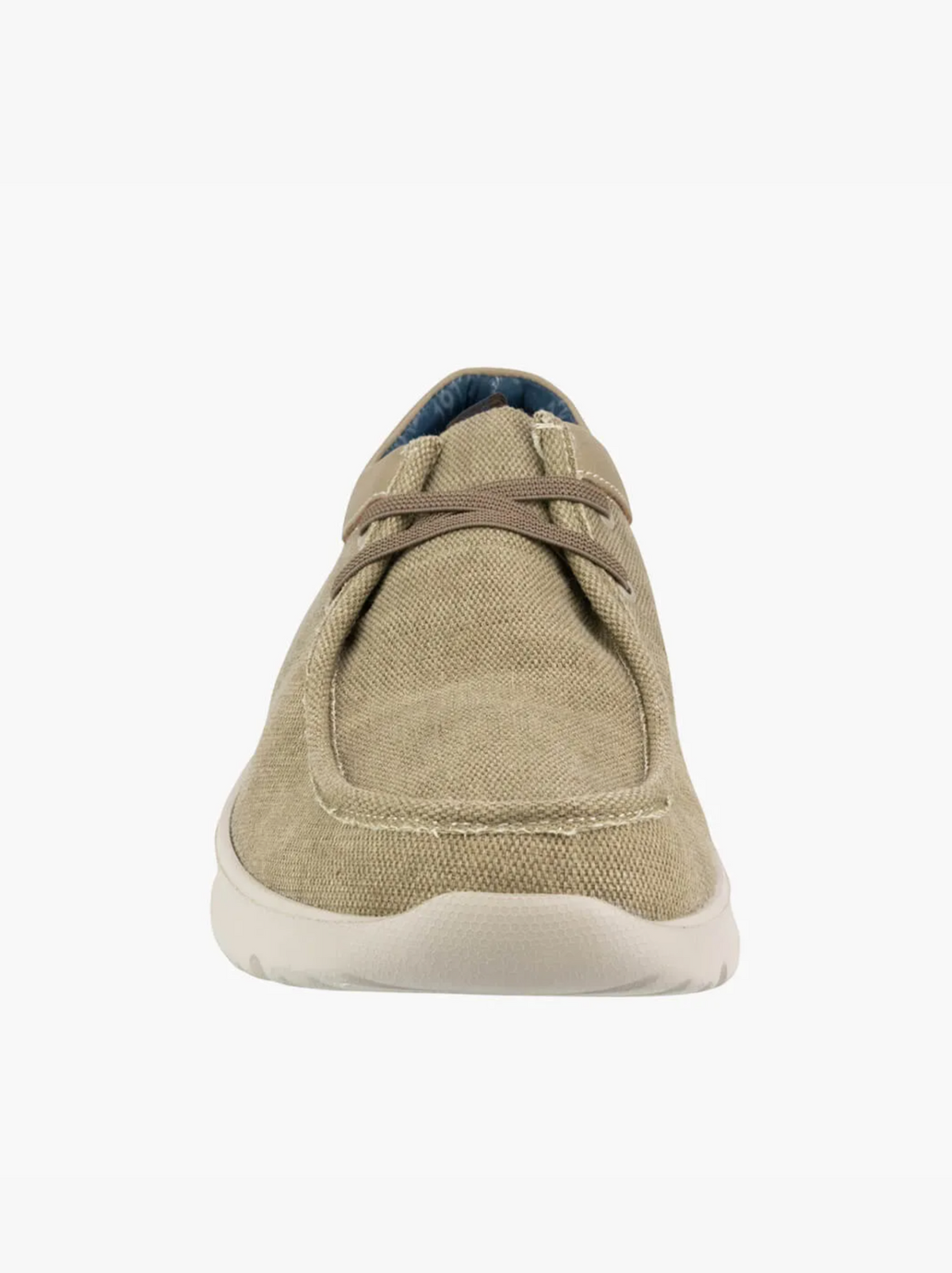 The Florsheim Bushwacker Canvas Slip On is a beige casual shoe with brown laces, a white sole, and a memory foam insole. It features a rounded toe and visible stitching, set against a plain white background.