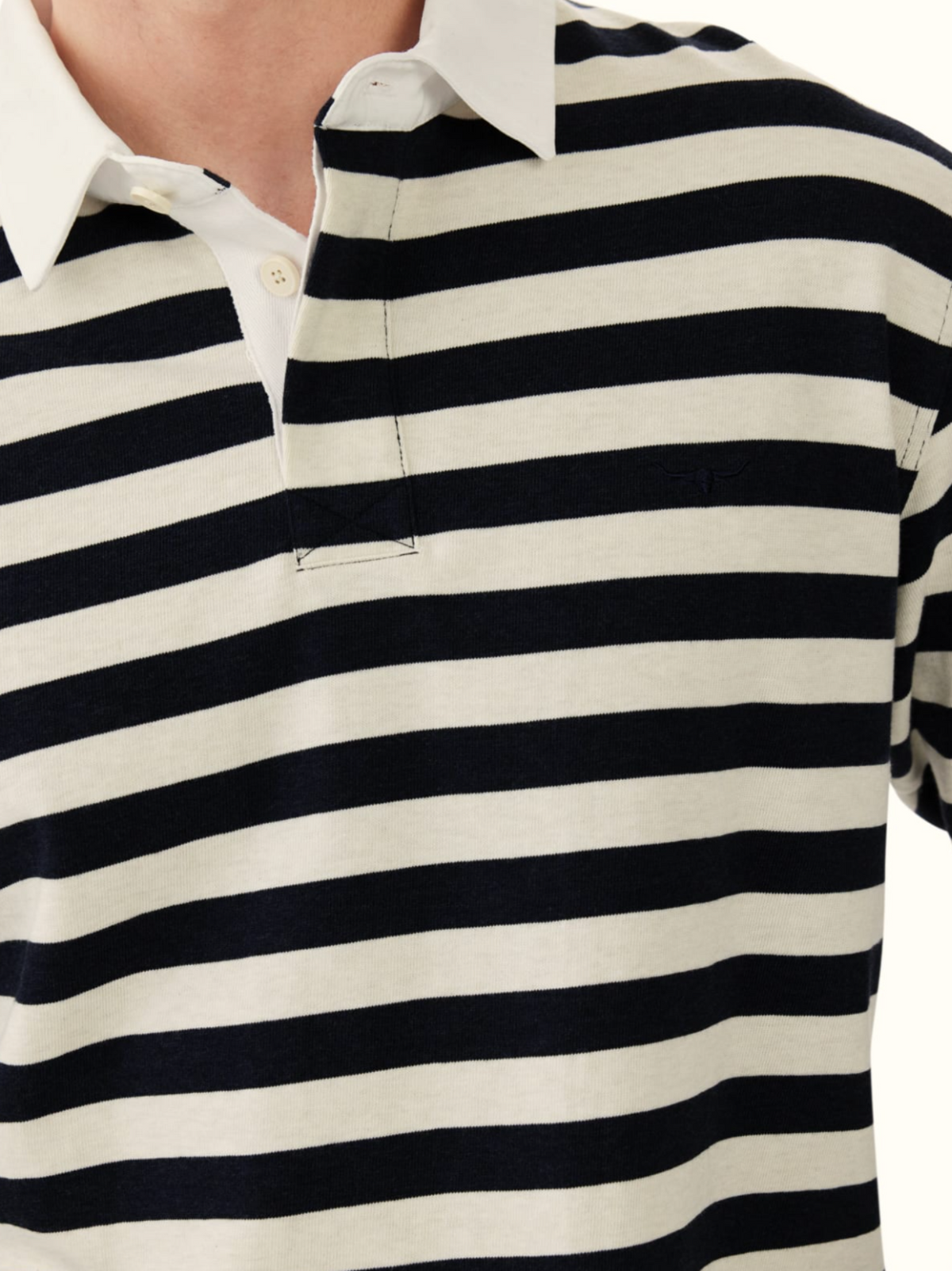 Wearing the RM Williams Tweedale Rugby—a collared, long-sleeve shirt with black and white horizontal stripes and a cotton twill collar. Only the torso and lower face are visible.