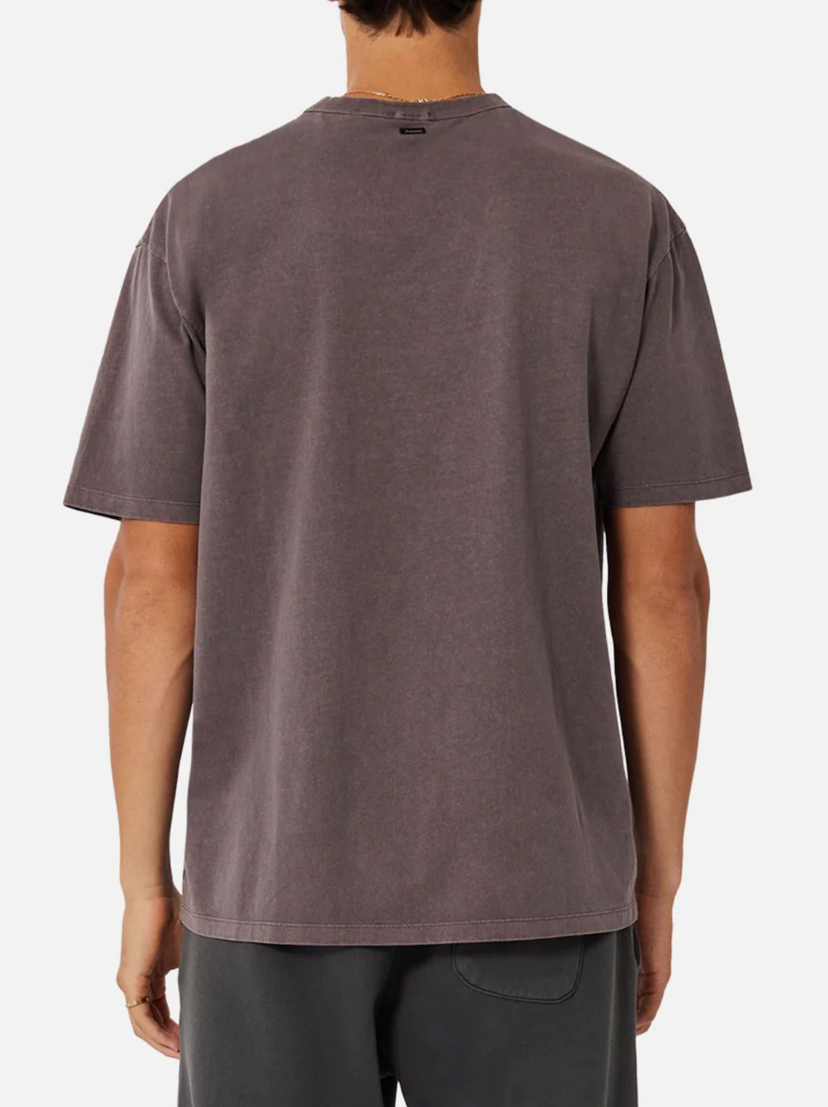 A person is shown from the back wearing an oversized Industrie The Del Sur Tee and dark shorts against a plain white background.