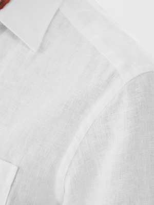 Close-up of the RM Williams Coalcliff Shirt highlighting the shoulder and upper sleeve. The 100% linen fabric features a textured weave pattern with a classic collar, exuding a light and airy vibe under the lighting.