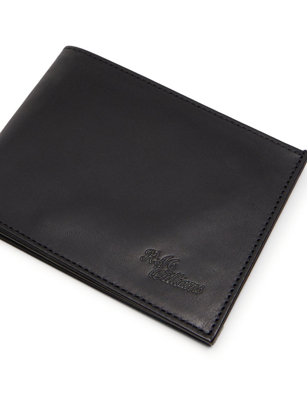 The RM Williams Singleton Bi-fold Wallet is a sleek, closed design in black calf leather with subtle edge stitching. It boasts an embossed logo on the bottom right, smooth and polished texture, and RFID protection for enhanced security.