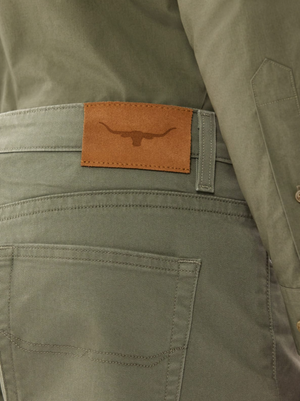 A person is wearing RM Williams Nicholson Shorts made from premium stretch cotton in gray, with a brown leather patch and bull's head logo on the back pocket, paired with a matching gray jacket for a smart casual look.