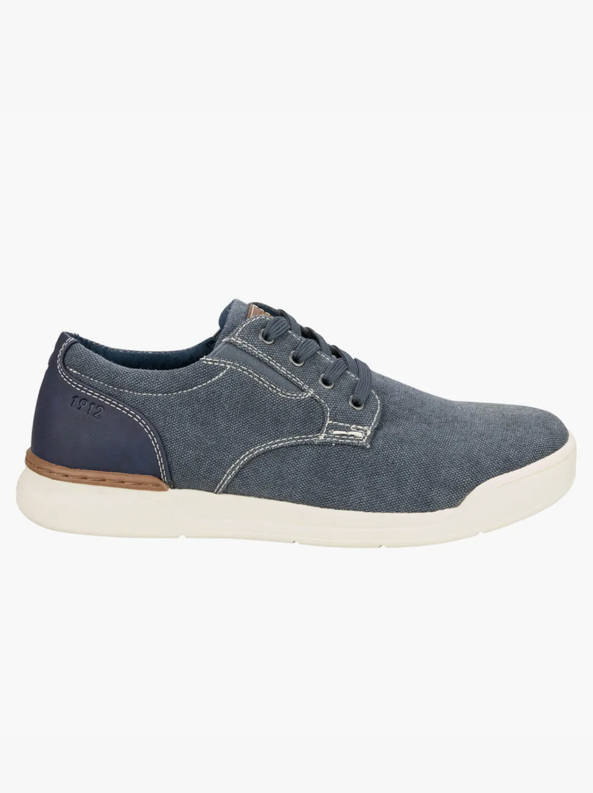 The Florsheim Kore Tour Canvas Lace Sneaker is a casual low-top shoe crafted from blue denim and breathable mesh, featuring white stitching, a white rubber sole, and a dark blue heel patch with "Florsheim" branding.