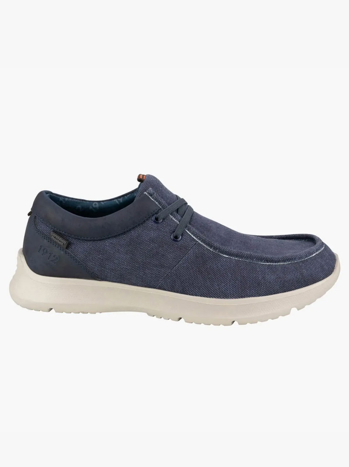The Florsheim Bushwacker Canvas Slip On is shown in navy blue with an organic cotton upper, white rubber sole, and navy laces, displayed in side profile on a plain white background.