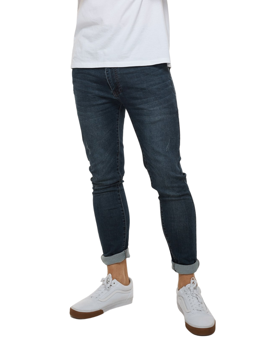 A person wearing Industrie The Denim Drifter NC Pant, skinny fit and cuffed at the ankles, paired with a white T-shirt and white sneakers with brown soles. The photo focuses on the lower body, cropped at the shoulders.