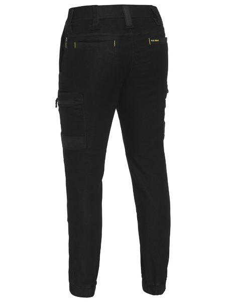 Back view of Bisley Flex & Move Stretch Denim Cargo Cuffed Pant in black shows visible stitching, side cargo pockets, and belt loops at the waist. Crafted from stretch knit denim, the fabric is sturdy and designed for functionality with multiple pockets.