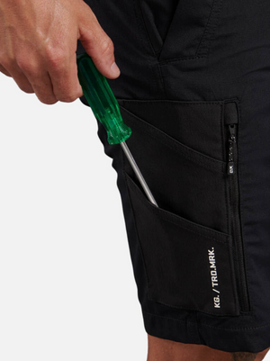 A person places a green-handled screwdriver into the pocket of black King Gee Trademark Cargo Shorts.