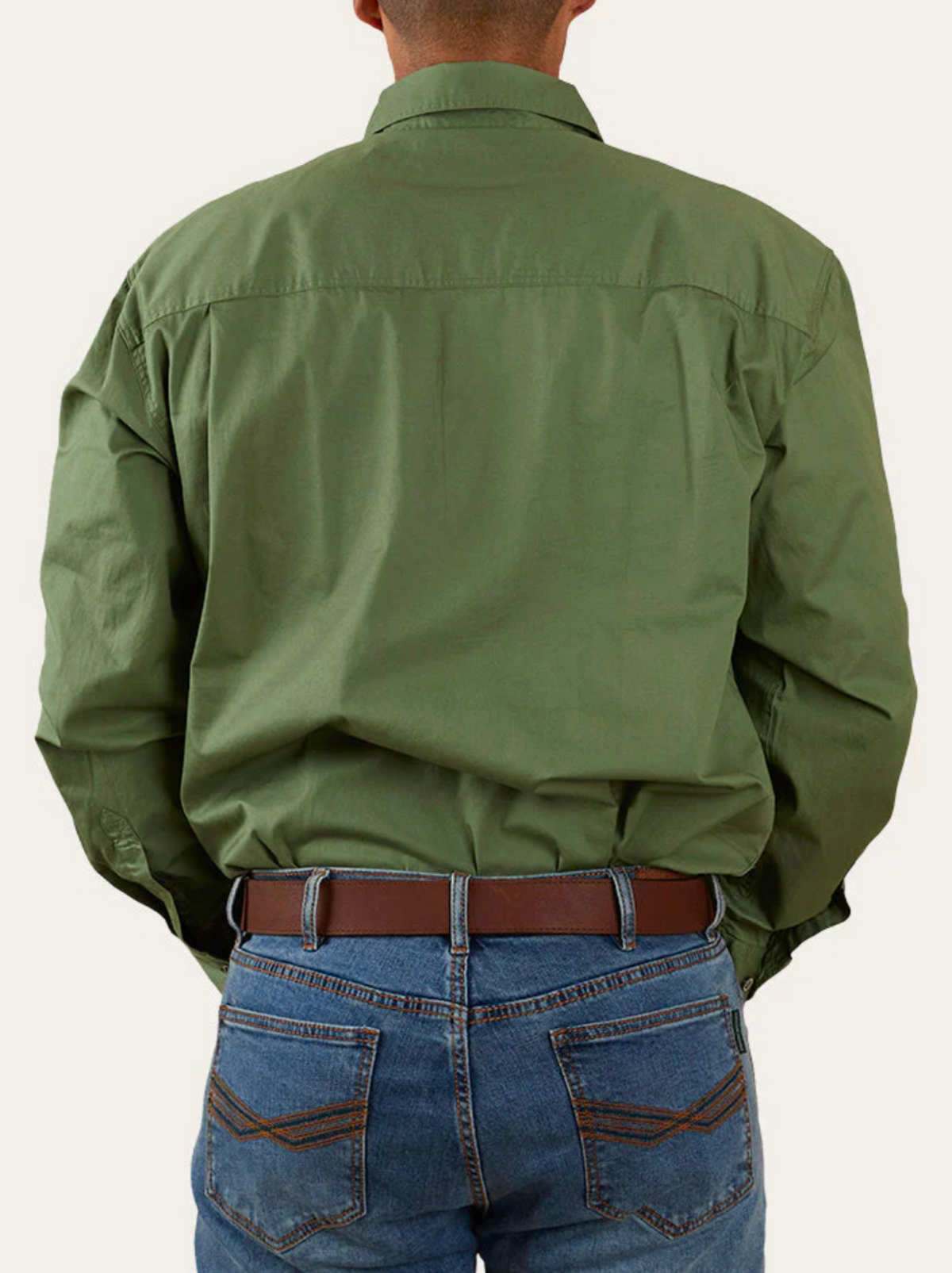 A person wearing a long-sleeved, olive green Ringers Western King River Half Button Shirt and blue jeans with a brown belt is seen from the back. The shirt is untucked, and the jeans have visible back pockets with stitching detail.