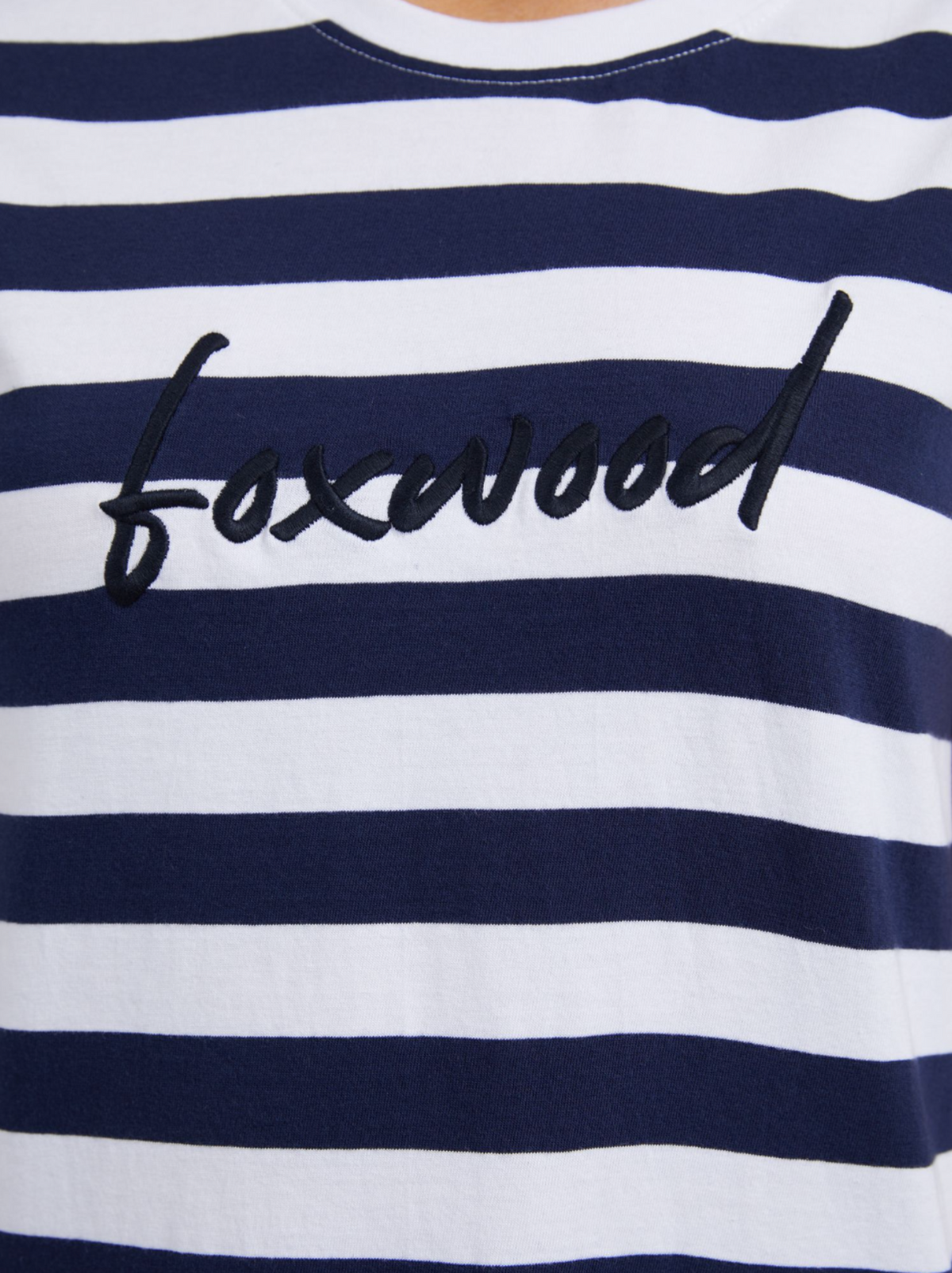 A close-up shows the Foxwood Signature Stripe Tee Dress made from 100% cotton jersey, in navy and white stripes, with "foxwood" embroidered in black cursive on the chest.