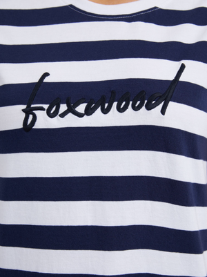 A close-up shows the Foxwood Signature Stripe Tee Dress made from 100% cotton jersey, in navy and white stripes, with "foxwood" embroidered in black cursive on the chest.