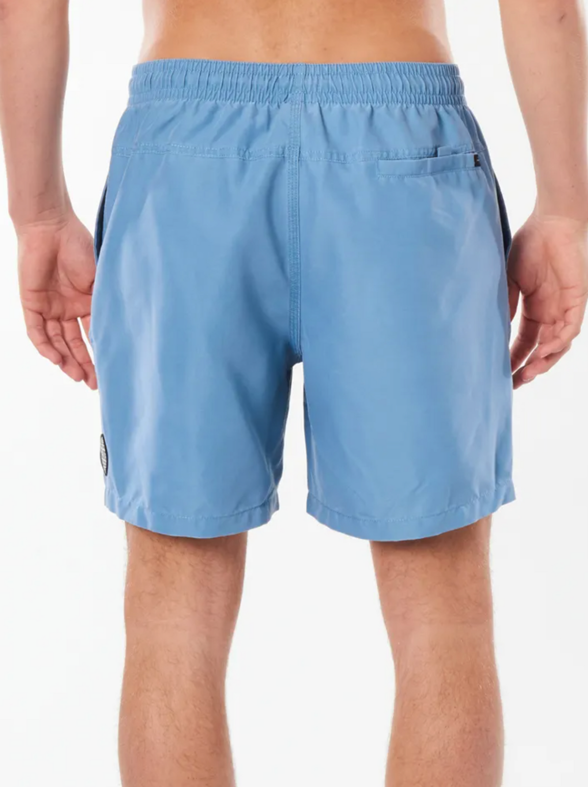 A person is seen from behind in light blue Rip Curl Bondi Volley swim trunks, featuring an elastic waistband and a back pocket. The slightly loose-fitting shorts end above the knees, ideal for a beach outing. The background is plain white.