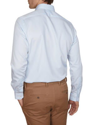 A man is shown from the back wearing an Abelard Non Iron Cotton Twill Slim Fit Shirt in light blue with a cutaway collar and tan dress pants, his left hand in his pocket.