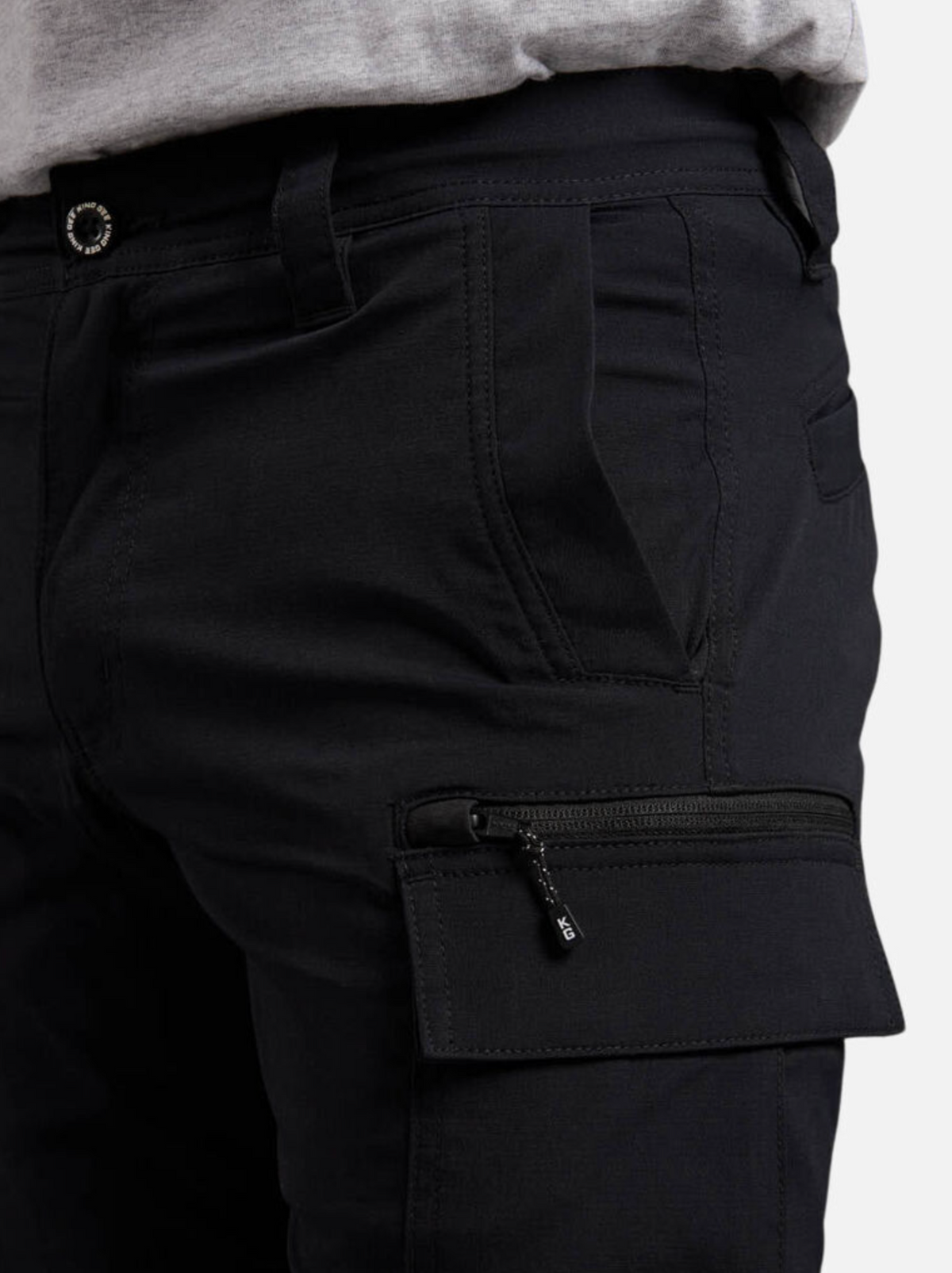 Close-up of a person wearing King Gee Trademark Cargo Short with a zipper pocket on the thigh, made from durable Stretch Ripstop fabric, and a grey shirt tucked in at the waist.