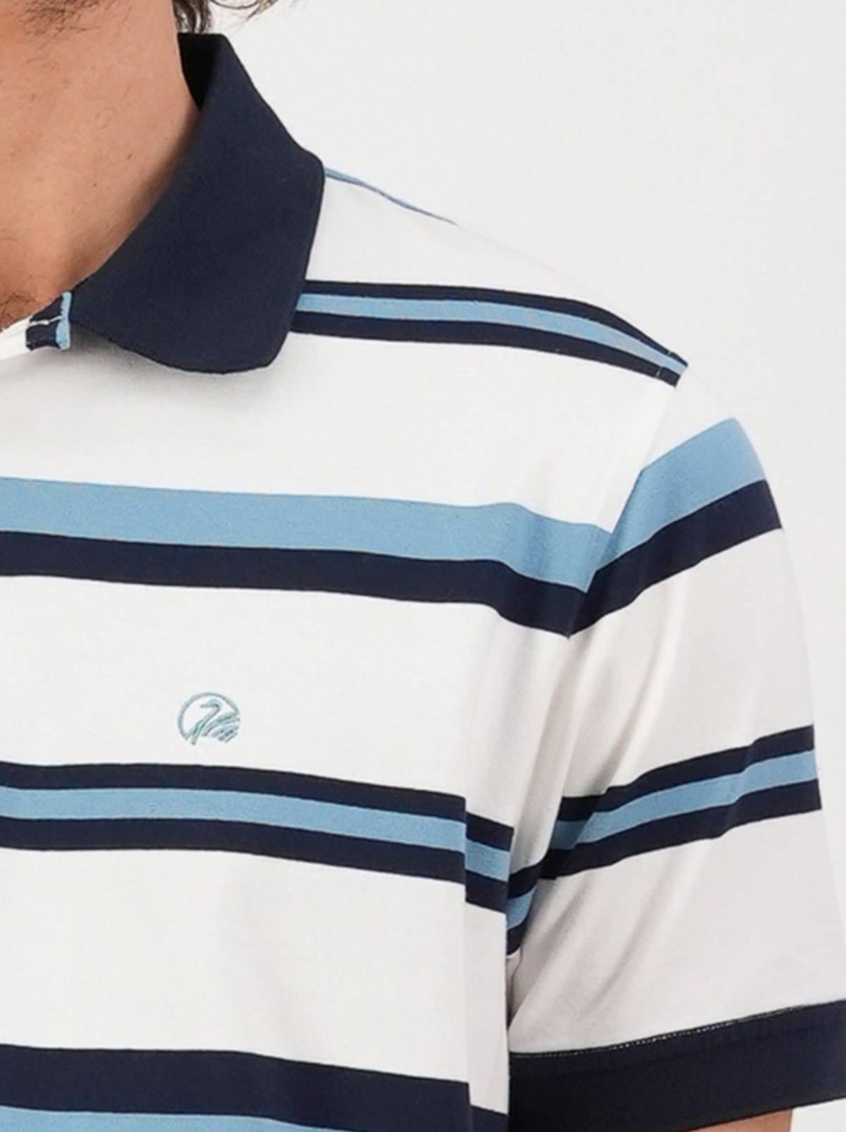 Wearing a Swanndri Winfred Stripe Polo offers comfort and style with its navy and light blue stripes on white, complemented by a navy collar and an embroidered logo on the chest.