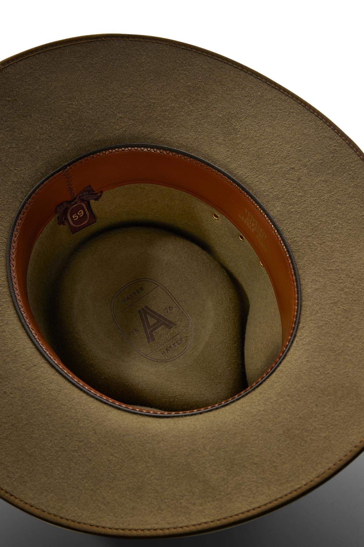 A close-up of the Akubra Cattleman hat’s green felt interior with brown leather trim, size label "59," and branded inner crown—ideal for outdoor adventurers who value rugged sophistication.