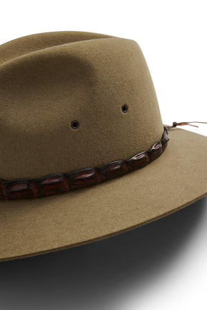 A close-up of the Akubra Coolabah, an Australian-style brown felt hat with a wide brim and a decorative crocodile leather band featuring a dark, textured pattern around the crown.