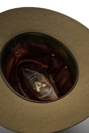 A close-up of the Akubra Coolabah hat's interior shows a satin lining, a label with a gold “A” and “Master,” plus a round tag indicating size 57.