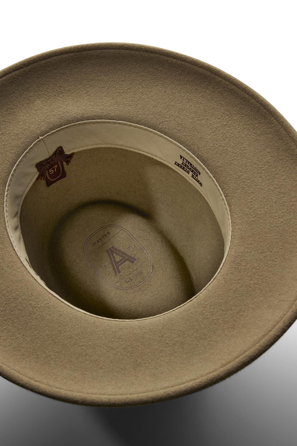 A close-up of the Akubra Traveller hat’s tan interior reveals a fabric sweatband, size 57 marking, and brand details stamped on the crown, emphasizing its practical design.