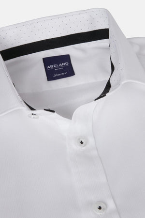 Close-up of the Abelard Bedford Dobby Slim Fit Shirt, made from 100% cotton with black buttons and a dark blue "Abelard Limited" label inside the collar. Features a subtle dotted pattern on the inner cardinal cut away collar lining.