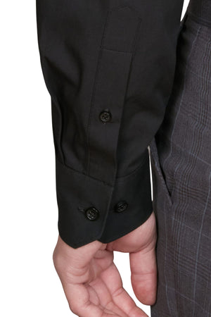 A close-up of a person's arm wearing the Abelard 4 Way Stretch Poplin Slim Fit shirt with buttoned cuffs and gray pinstripe pants, their hand resting by their side.