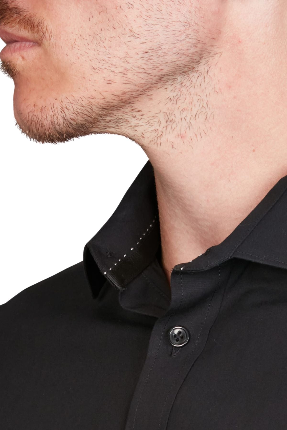 Close-up of a man's lower face with light stubble, wearing the Abelard 4 Way Stretch Poplin Slim Fit shirt in black, featuring a visible button and white stitching detail at the collar. Made from wrinkle-resistant, 4-way stretch poplin.
