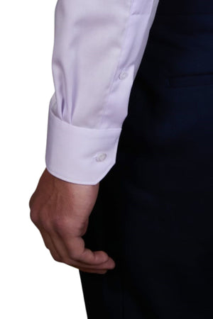 A person wearing the Abelard Non Iron Cotton Twill Slim Fit Shirt in white with buttoned cuffs and dark pants, showing only their arm and hand at their side against a plain background.
