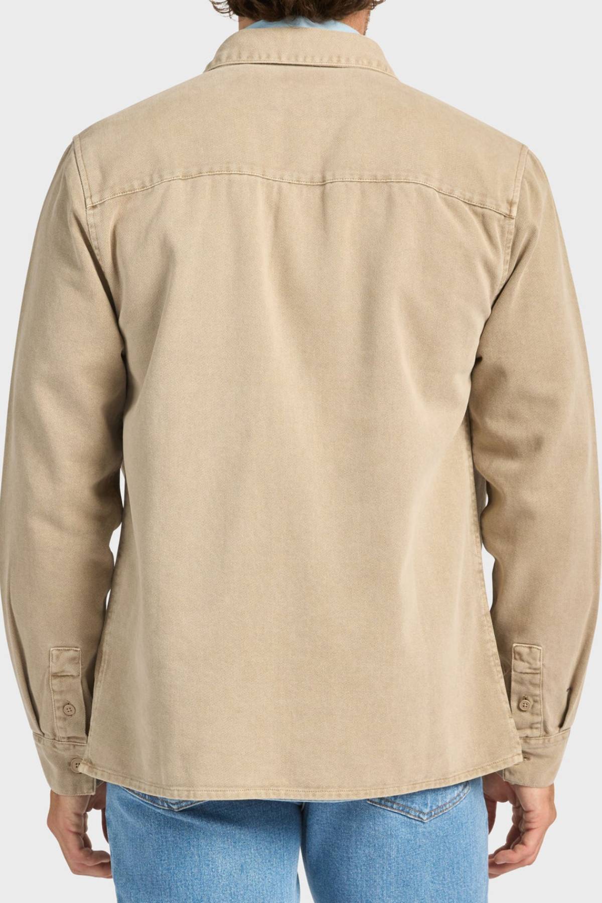 A person wearing the Academy Brand Essential Overshirt in beige cotton twill with double chest pockets and blue jeans, seen from the back against a white background.