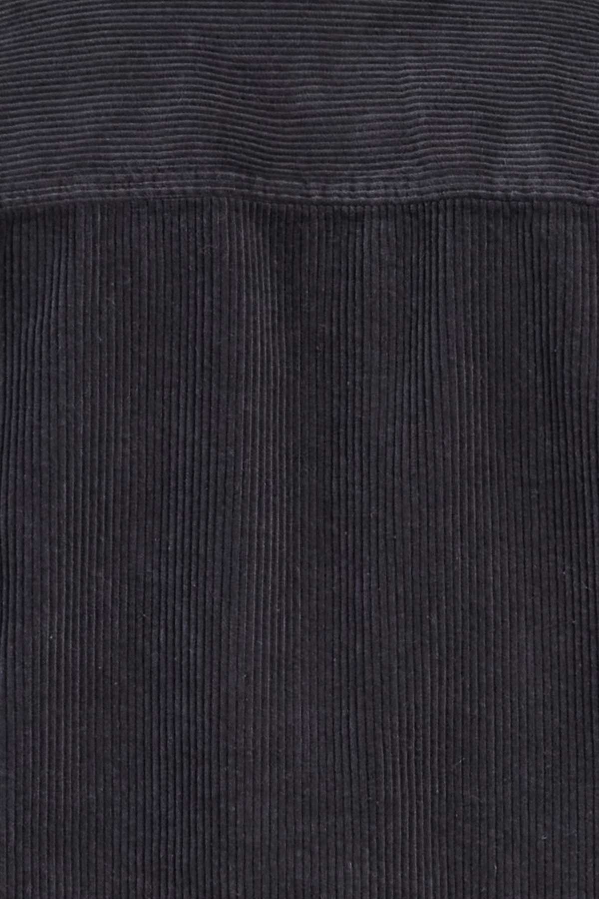 Close-up view of the dark gray, mid-weight corduroy fabric texture of the Academy Brand Lebowski Cord Overshirt, showcasing its vertical ridges and soft, tactile appearance. This 100% cotton fabric's parallel lines create a sense of depth and pattern, making it perfect for a stylish shirt.
