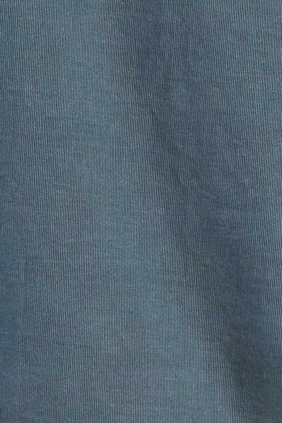A close-up view of the teal-colored, 100% cotton corduroy fabric from the Academy Brand Micro Cord Shirt, highlighting its characteristic vertical ridged pattern and texture. The fabric appears soft and slightly worn, complemented by imitation mother-of-pearl buttons.